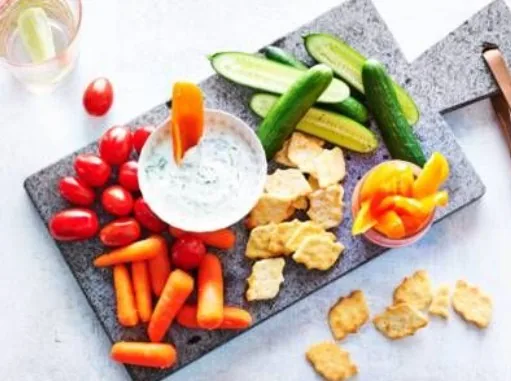 Plank met groenten, dip en crackers als avondsnack