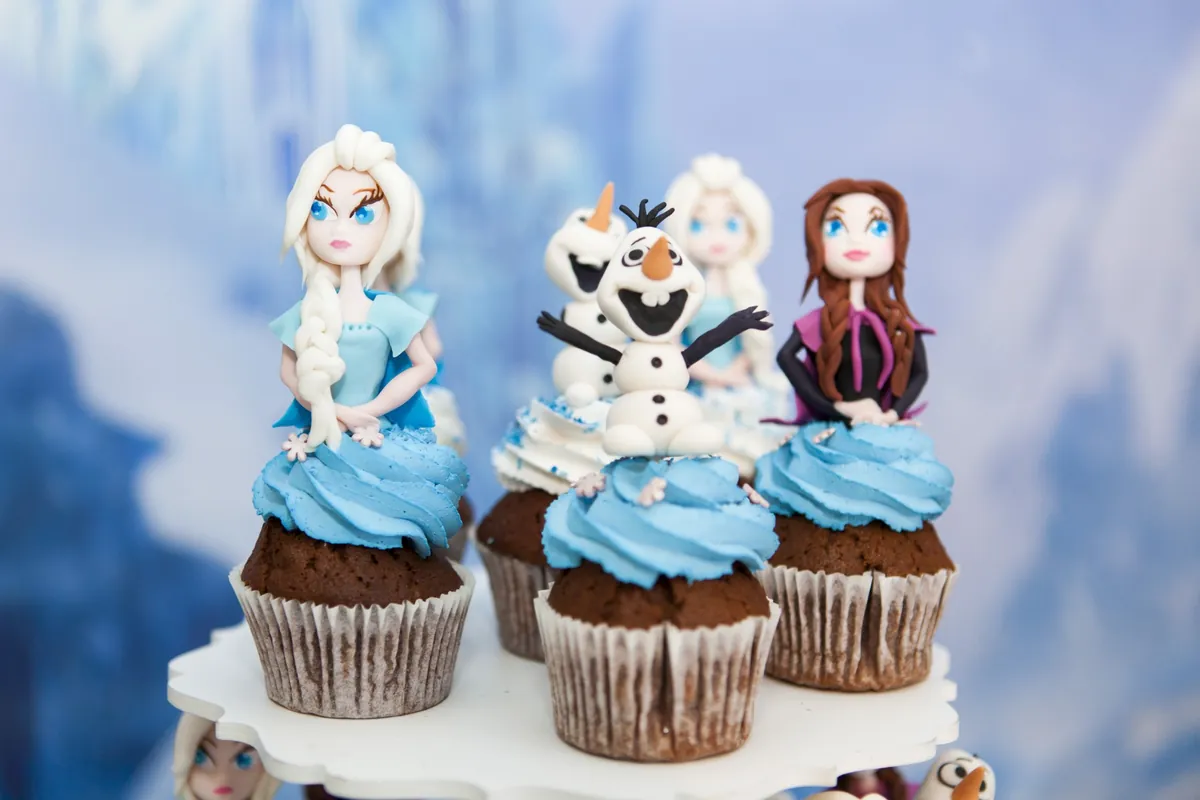 Cupcakes met blauw glazuur en figuurtjes als voorbeeld van suikerrijke traktaties voor kinderen